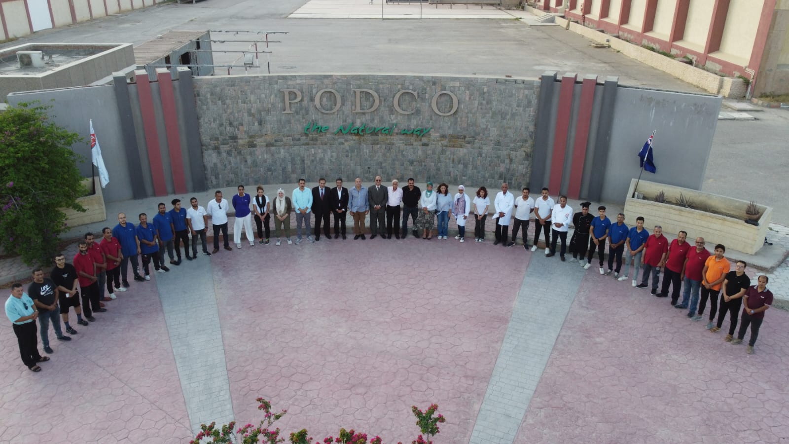 The PODCO team gathered at the factory archway