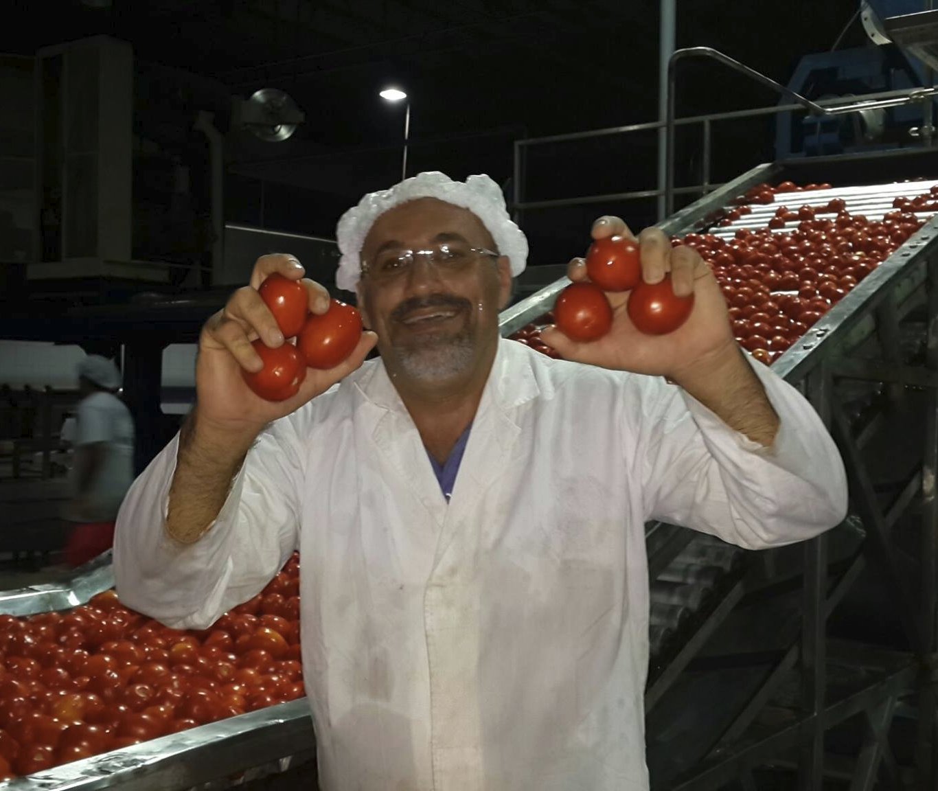 PODCO founder at the factory with fresh tomatoes